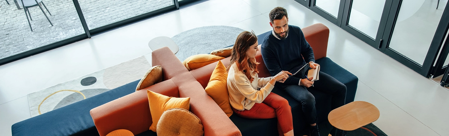 Two professionals reviewing a tablet in a modern office, representing Hays Total Workforce Solutions for managing talent needs with visibility and agility.