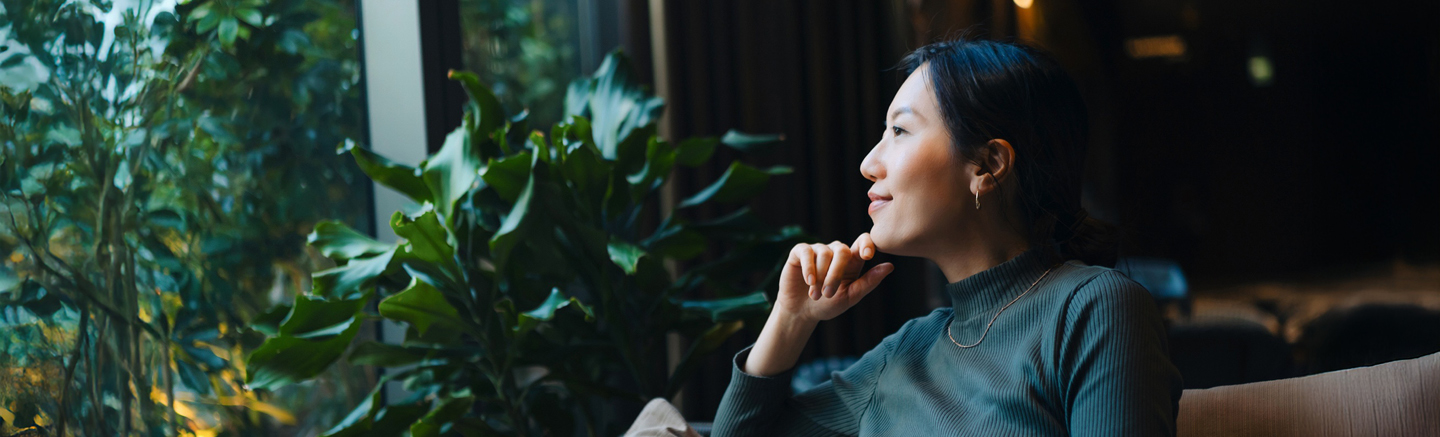 Person seated in a modern office setting beside indoor plants, representing strategic thinking and cost‑efficient workforce planning in the UK.