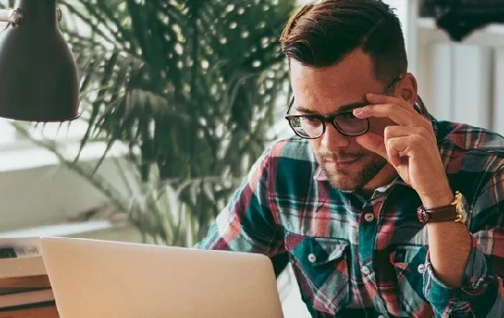Person working on a laptop in a home or office setting, representing online learning and skills development.